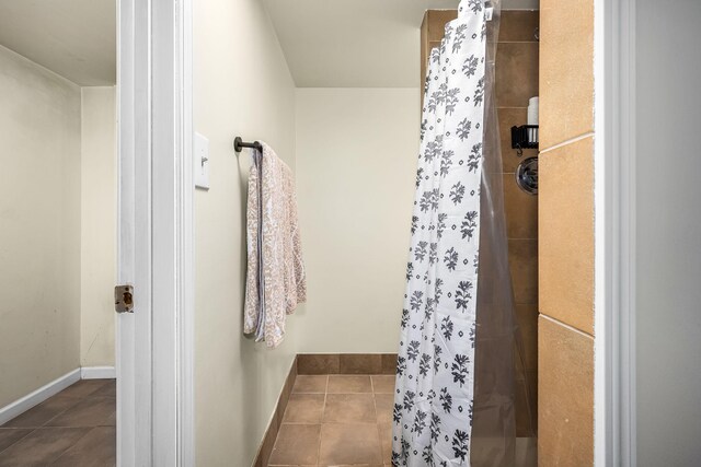 bathroom featuring tile patterned flooring and a tile shower