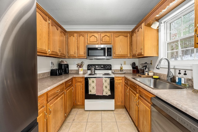 kitchen with sink, light tile patterned floors, stainless steel appliances, and a textured ceiling