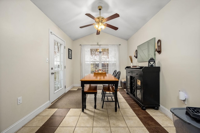 dining area featuring tile patterned floors, ceiling fan with notable chandelier, and vaulted ceiling