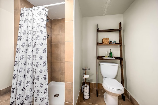 bathroom featuring tile patterned flooring, toilet, and walk in shower