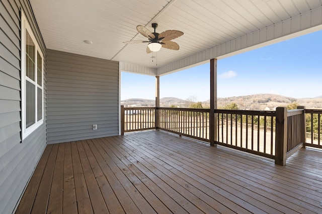 wooden terrace featuring ceiling fan and a mountain view