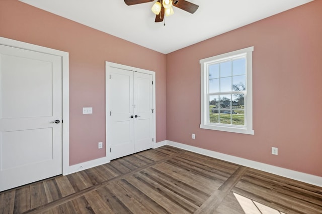 unfurnished bedroom with ceiling fan and dark hardwood / wood-style floors