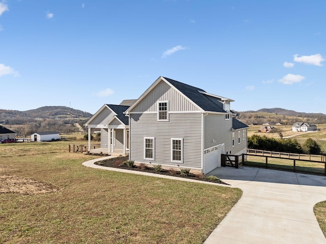 view of front of property featuring a mountain view, a garage, and a front lawn