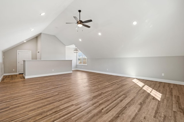 additional living space with vaulted ceiling, ceiling fan with notable chandelier, and hardwood / wood-style flooring