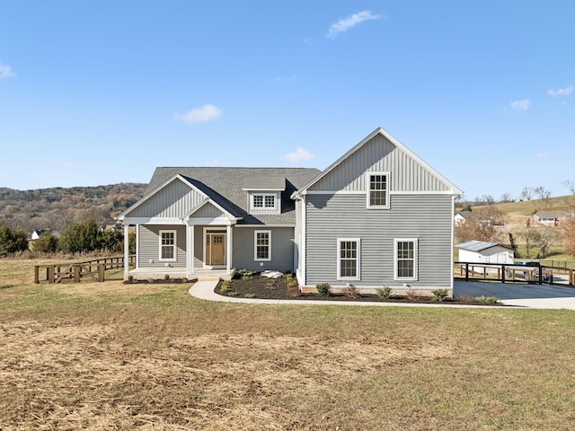 view of front of house featuring covered porch and a front lawn