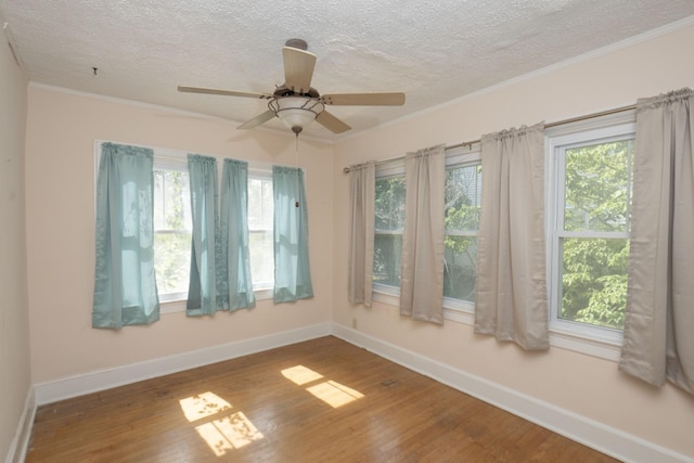 spare room featuring ceiling fan, hardwood / wood-style floors, a textured ceiling, and ornamental molding