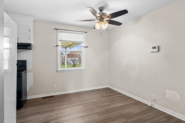 spare room featuring ceiling fan and dark wood-type flooring