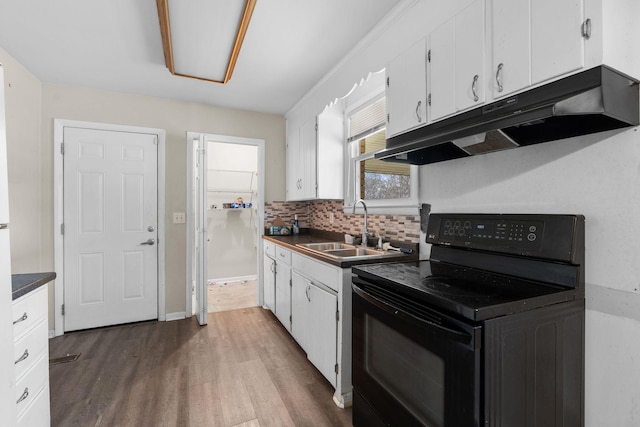 kitchen featuring decorative backsplash, sink, wood-type flooring, electric range, and white cabinetry