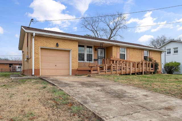 ranch-style home with covered porch, a garage, and a front yard