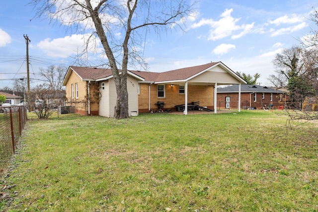 back of property with a lawn and a patio