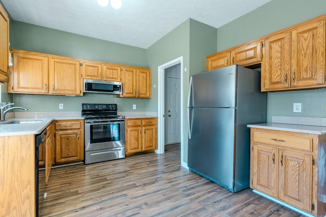 kitchen with sink, stainless steel appliances, and light wood-type flooring