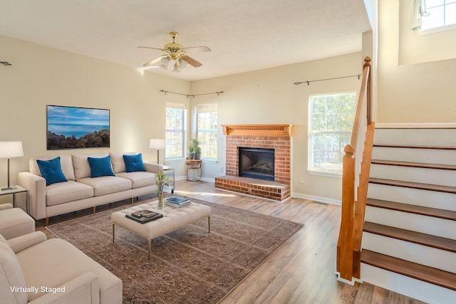 living room with a fireplace, hardwood / wood-style floors, and ceiling fan