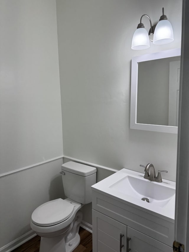 bathroom featuring hardwood / wood-style flooring, vanity, and toilet