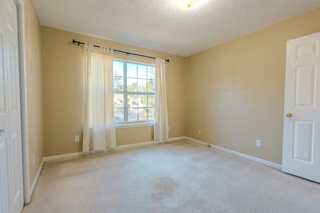 carpeted empty room with a textured ceiling