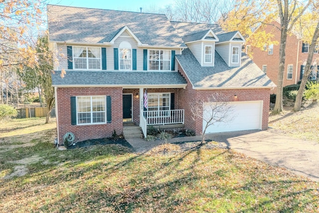 view of front of home with covered porch, a garage, and a front yard