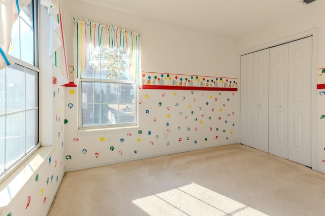 unfurnished bedroom with light carpet and a closet