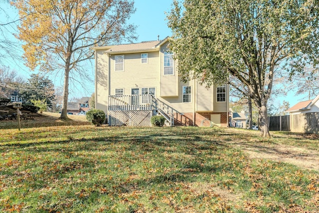 rear view of property with a yard and a wooden deck