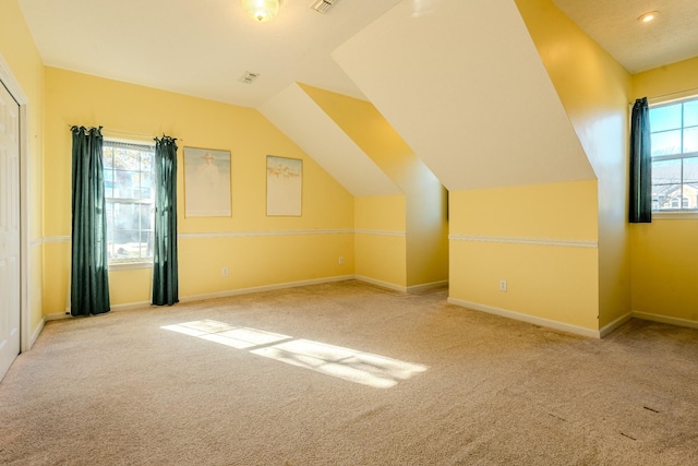 bonus room with light carpet and vaulted ceiling