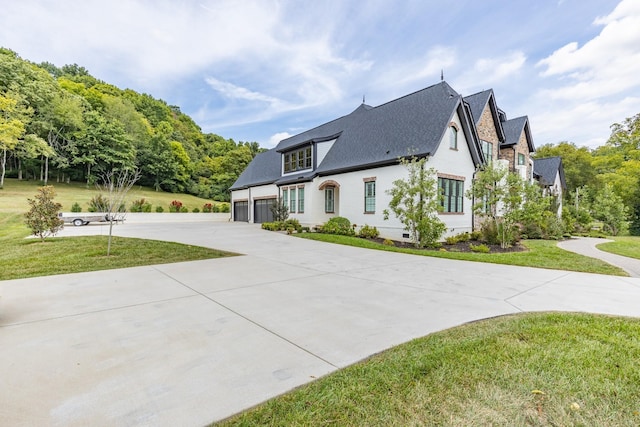 view of side of home with a lawn and a garage