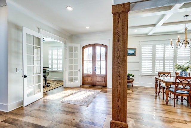 foyer featuring french doors, coffered ceiling, beamed ceiling, a notable chandelier, and wood-type flooring