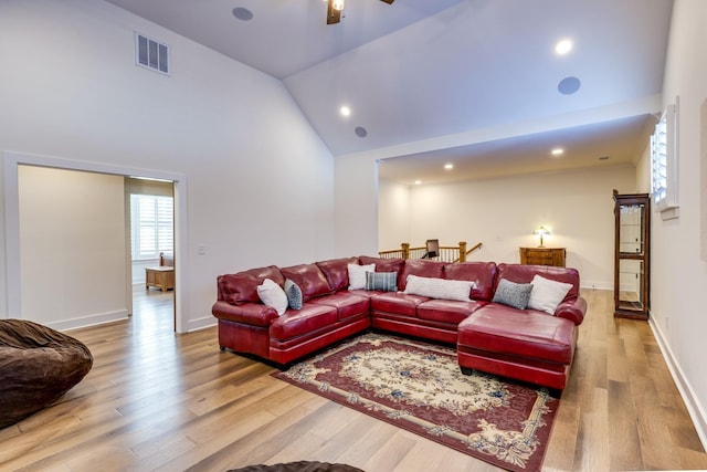 living room featuring ceiling fan, high vaulted ceiling, and light hardwood / wood-style flooring