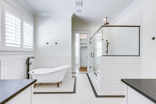 bathroom featuring vanity, independent shower and bath, tile walls, and ornamental molding