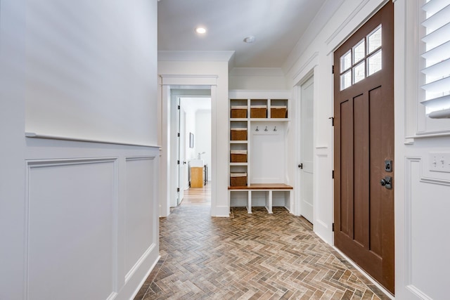 mudroom with ornamental molding and parquet flooring