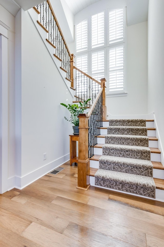 stairway with hardwood / wood-style flooring and a healthy amount of sunlight