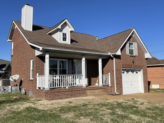 view of front of house featuring a garage, a front yard, and a porch