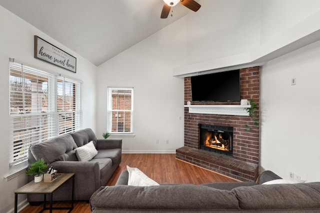 living room with ceiling fan, high vaulted ceiling, a fireplace, and hardwood / wood-style floors