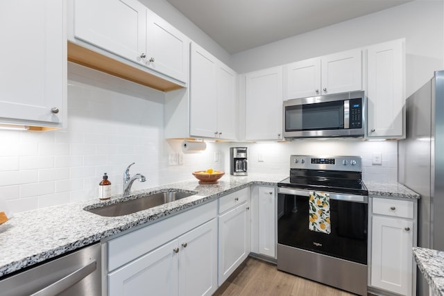 kitchen featuring white cabinets, light wood-type flooring, sink, and appliances with stainless steel finishes