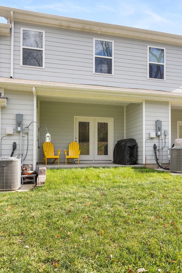 rear view of house with a lawn and central air condition unit