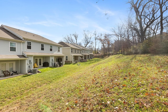 view of yard featuring central air condition unit, a patio, and french doors