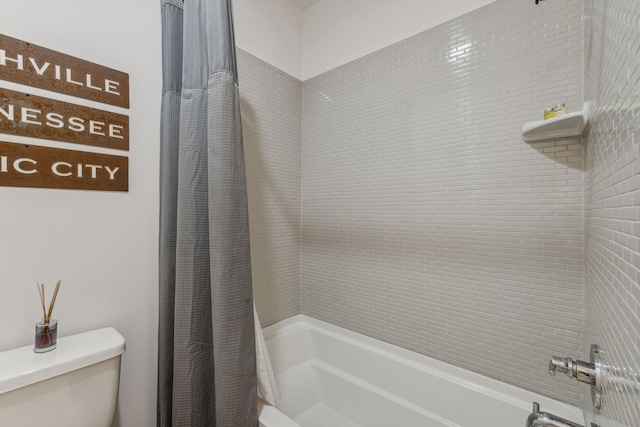 bathroom featuring shower / bath combination with curtain and toilet