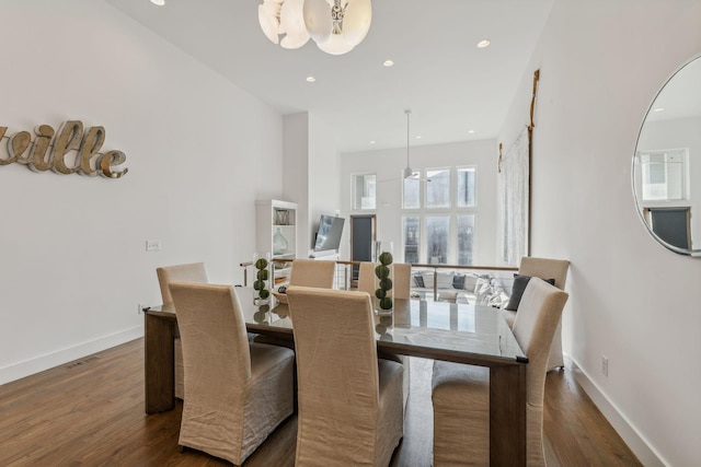 dining area featuring ceiling fan with notable chandelier and dark wood-type flooring