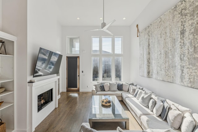 living room with ceiling fan and dark wood-type flooring