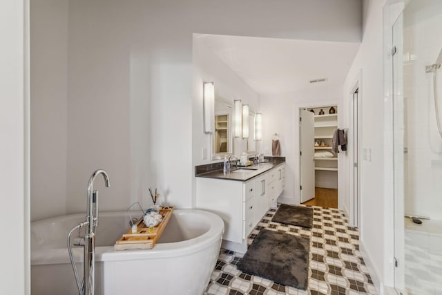 bathroom featuring vanity and independent shower and bath