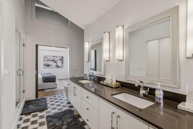 bathroom with wood-type flooring, vanity, vaulted ceiling, and a shower with shower door