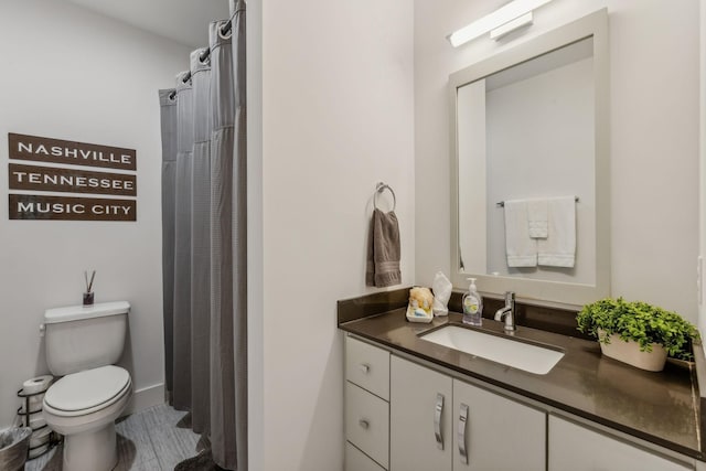 bathroom with a shower with curtain, vanity, and toilet