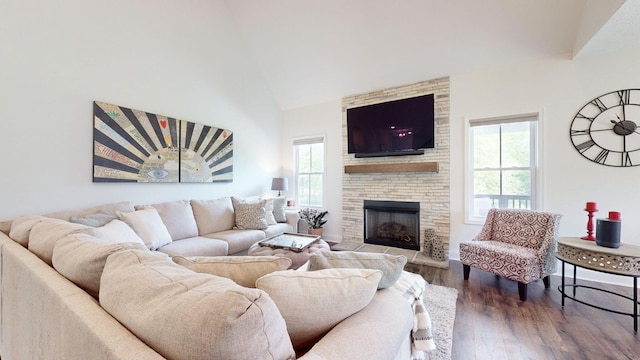 living room with a wealth of natural light, a large fireplace, dark wood-type flooring, and lofted ceiling