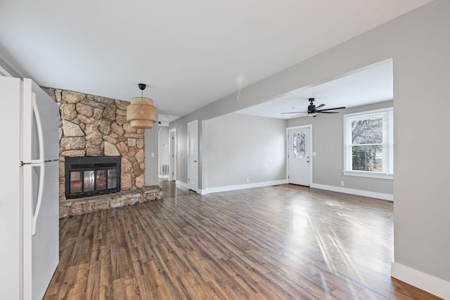 unfurnished living room with a stone fireplace, ceiling fan, and hardwood / wood-style flooring