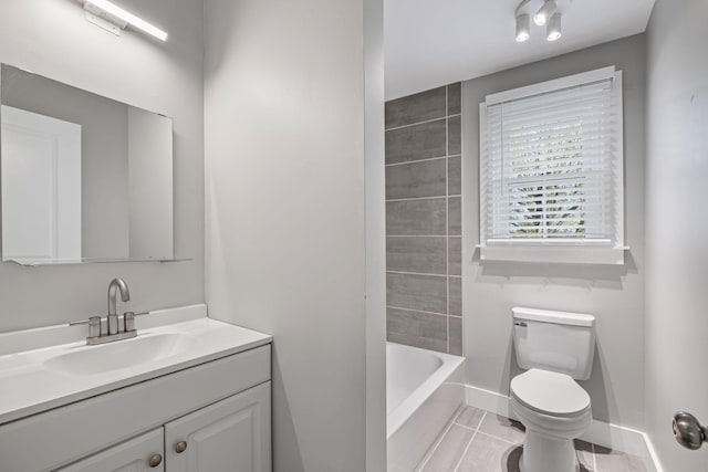 bathroom featuring toilet, vanity, tile patterned floors, and a tub