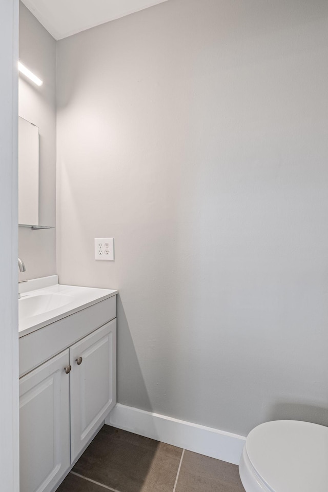 bathroom with tile patterned flooring, vanity, and toilet