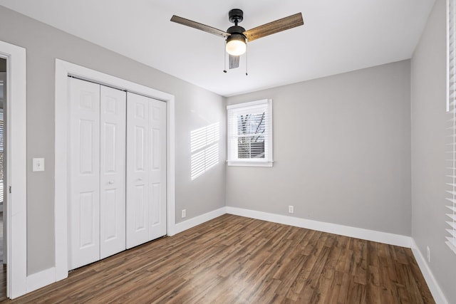 unfurnished bedroom featuring a closet, dark hardwood / wood-style floors, and ceiling fan