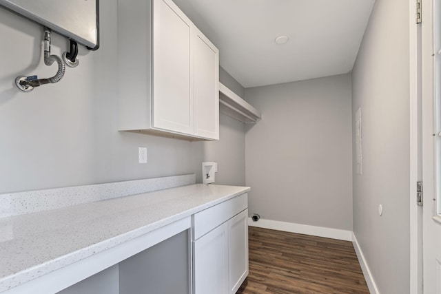 laundry room featuring cabinets, dark wood-type flooring, and hookup for a washing machine