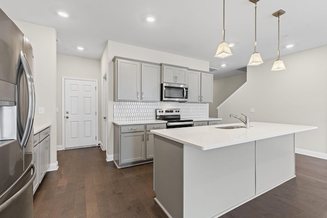 kitchen featuring sink, an island with sink, pendant lighting, and appliances with stainless steel finishes