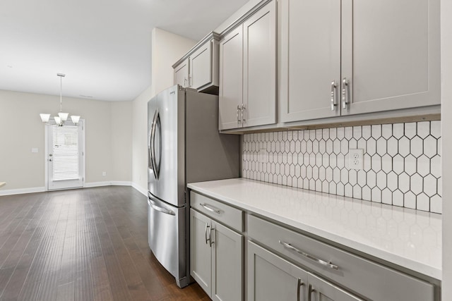 kitchen featuring gray cabinetry, decorative backsplash, hanging light fixtures, and an inviting chandelier