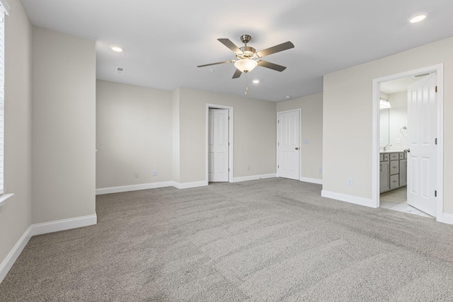 unfurnished room featuring light carpet, ceiling fan, and sink