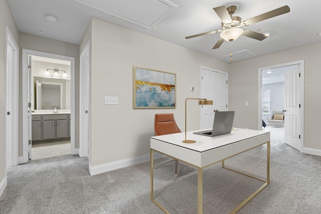 home office featuring ceiling fan, sink, and light colored carpet