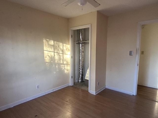 unfurnished bedroom with dark hardwood / wood-style floors, a closet, and ceiling fan